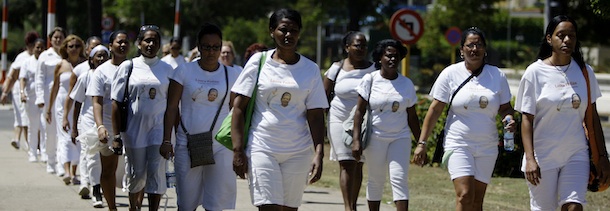Members of dissident group Ladies in White take part in their weekly march in front of Santa Rita church in Havana, Cuba, Sunday March 18, 2012. Dissident Angel Moya says police detained his wife Bertha Soler and three dozen supporters of the Ladies in White dissident group on Sunday morning. The detentions come just over a week ahead of a visit by Pope Benedict XVI, who is likely to bring up the issue of religious, political and human rights during his tour. The image of the woman on their shirts is of Laura Pollan, the group's former leader who died in 2011 of a heart attack. (AP Photo/Franklin Reyes)