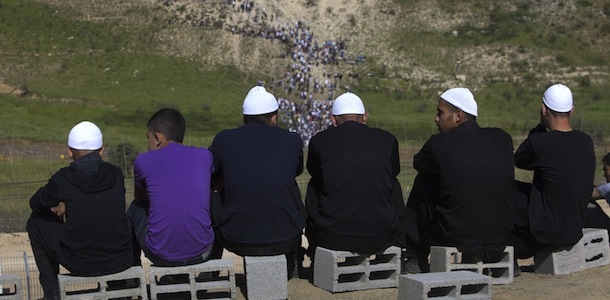 Residents of the Druze village of Majdal Shams in the Israeli-annexed Golan Heights watch as demonstrators gather along the Syrian border with Israel (background), on June 5, 2011, as Israeli troops opened fire as protestors from Syria stormed a ceasefire line in the occupied Golan Heights, killing six demonstrators, according to Syrian state media. AFP PHOTO/MENAHEM KAHANA (Photo credit should read MENAHEM KAHANA/AFP/Getty Images)