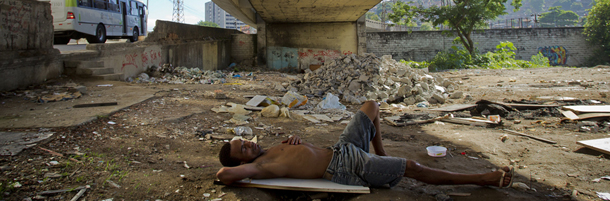 A homeless man sleeps where houses were demolished in the Favela do Metro shantytown in Rio de Janeiro, Brazil, Wednesday, Feb. 1, 2012. Residents of communities like Metro, located on the surroundings of the Maracana stadium, are being pushed out of their homes to make way for new roads, Olympic venues, and other projects as part of preparations to host the 2014 World Cup and the 2016 Olympics. (AP Photo/Victor R. Caivano)