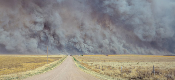 In a Sunday, March 18, 2012 photo provided by the Yuma, Colo., Pioneer, a wildfire sends up a huge wall of smoke, forcing authorities to temporarily close a section of U.S. Highway 34 east of Yuma County, Colo., when the fire filled the skies with so much smoke that firefighters couldn't see the flames. Evacuated residents of the small Colorado town of Eckley have been allowed to return home after firefighters contained most of the wildfire. (AP Photo/The Yuma Pioneer, Tony Rayl)