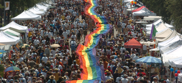 Festival goers hold on to a large rainbow flag stretching several blocks down Central Ave., after the St. Pete Pride Promenade in St. Petersburg, Fla., Saturday, June 26, 2004. (AP Photo/Tampa Tribune, Michael Spooneybarger)