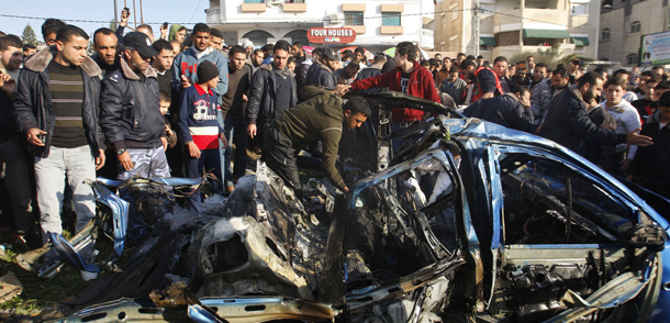 Palestinians gather around the wreckage of a car targeted in an airstrike in Gaza City, Friday, March 9, 2012. An Israeli airstrike killed top Palestinian militant commander Zuhair al-Qaissi and a second militant in Gaza on Friday in the highest profile attack against the coastal strip in months. (AP photo/Hatem Moussa)