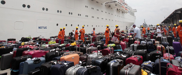 Passengers of the Costa Allegra cruise ship look for their baggage upon their arrival at Victoria's harbor, Seychelles Island, Thursday, March 1, 2012. A disabled cruise ship carrying more than 1,000 people docked in the island nation of the Seychelles Thursday after three days at sea without power since a fire broke out in the generator room on Monday. (AP Photo/Gregorio Borgia)