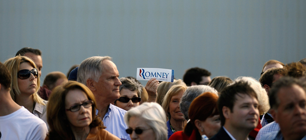 JACKSONVILLE, FL - JANUARY 26: A supporter holds up a bumper sticker while waiting for the start of a campaign event with Republican presidential candidate and former Massachusetts Gov. Mitt Romney at Paramount Printing January 26, 2012 in Jacksonville, Florida. Romney spoke at the printing business because President and CEO John Cummins said health care costs, Occupational Safety and Health Administration regulations, the loss of business and other factors have forced the company to close. Recent polls show that Romney and fellow GOP candidate, former Speaker of the House Newt Gingrich (R-GA), are in a statistical tie heading into next Tuesday's Florida primary. (Photo by Chip Somodevilla/Getty Images)