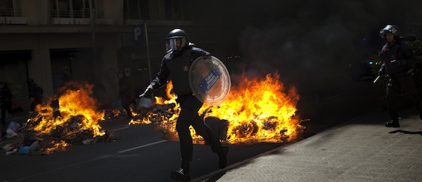Riot police officers run during clashes with demonstrators during the general strike in Barcelona, Thursday, March 29, 2012. Spanish unions angry over economic reforms are waging a general strike, challenging a conservative government not yet 100 days old and joining other troubled European workers in venting their frustration on the street. (AP Photo/Emilio Morenatti)