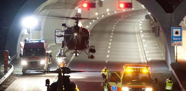 A rescues helicopter is airborne Rescuers work at the tunnel entrance after a bus crashed in the tunnel, in Sierre, Switzerland, early wednesday, March 14, 2012. (KEYSTONE/Laurent Gillieron)