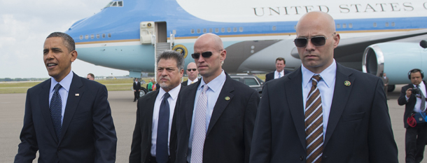 US President Barack Obama (L), surrounded by US Secret Service agents, walks to greet guests upon arrival on Air Force One at Tampa International Airport in Tampa, Florida, on April 13, 2012. Obama arrived in Tampa to speak at the Port of Tampa, before continuing to the Summit of the Americas in the Colombian city of Cartagena. AFP PHOTO/Saul LOEB (Photo credit should read SAUL LOEB/AFP/Getty Images)