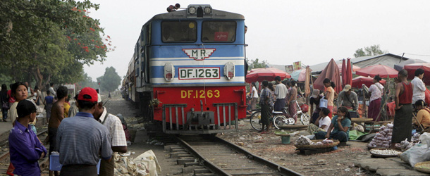 In this photo taken on Sunday, April 22, 2012, passengers and vendors wait to get on a commuter train on its arrival at railway station in Yangon, Myanmar. (AP Photo/Khin Maung Win)