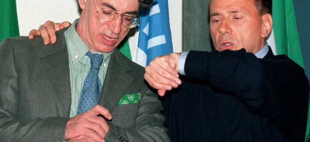 ** FILE ** Italian premier Silvio Berlusconi, right, and Umberto Bossi, leader of the Northern League, check time in this April 28, 2000 file photo. Berlusconi and Bossi are reportedly having a meeting in the clinic in Brissago, Switzerland, where Bossi is hospitalized, Tuesday, Nov. 16, 2004 . (AP Photo/Carlo Vitello/Agi)