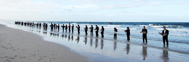 &lt;&gt; on January 8, 2012 in Adelaide, Australia. Surrealist artist, Andrew Baines recruited 100 volunteers for this human installation, meant to illustrate corporate workers enjoying nature rather than waiting in a long queue for a trip to work.