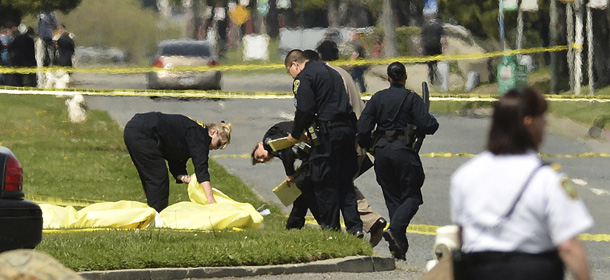 Oakland Police cover bodies near Oikos University in Oakland, Calif., Monday, April 2, 2012. A gunman opened fire at Oikos University in California Monday, killing at least five people, law enforcement sources close to the investigation said. Police say they have a suspect in custody. (AP Photo/Noah Berger)
