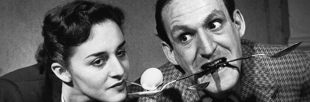 A woman tries to pick three eggs from a box and transfer them to the three spoons held in her partner's mouth in a stunt arranged for the "Beat The Clock" television show in New York, March 8, 1952. (AP Photo/ho)