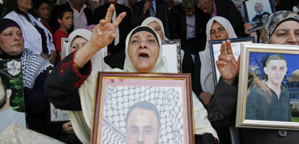 Palestinian prime minister Salam Fayyad (C-back) addresses demonstrators at a protest tent in the West Bank town of Bethlehem in solidarity with over 1,550 prisoners observing a hunger strike to demand better conditions in Israeli jails on May 12, 2012. The World Health Organisation urged Israel to give quick and suitable health care to Palestinian hunger strikers, including their transfer to civilian hospitals. AFP PHOTO/MUSA AL-SHAER (Photo credit should read 