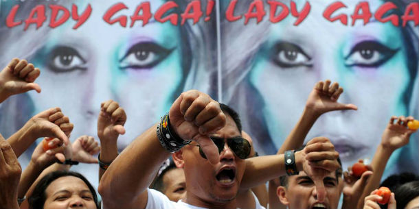Members of Biblemode Youth Philippines gesture during a protest in front of a banner showing Lady Gaga in Manila on May 19, 2012. Lady Gaga was warned on May 18 to refrain from nudity, lewd conduct and blasphemy when her Asian tour reaches the Philippines next week, after her controversial act was banned by neighbouring Indonesia. AFP PHOTO/NOEL CELIS (Photo credit should read NOEL CELIS/AFP/GettyImages)