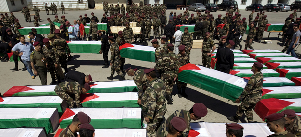 Palestinian security forces carry flag-draped coffins during preparations for the funeral procession of 91 Palestinians whose remains were returned by Israel in the West Bank city of Ramallah on May 31, 2012. Israel handed over the remains of scores of Palestinian militants killed in attacks against Israel, a Palestinian official said. AFP PHOTO/AHMAD GHARABLI (Photo credit should read AHMAD GHARABLI/AFP/GettyImages)