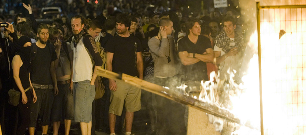 Protesters watch a fire during a demonstration in Montreal, Saturday, May 19, 2012. A plan to restore order in Montreal appeared to erupt in smoke late Saturday, with a fiery blockades blazing on busy downtown streets.(AP Photo/Graham Hughes, The Canadian Press)
