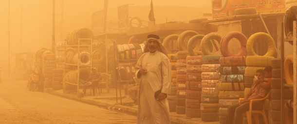An Iraqi man stands in a Baghdad street, in a yellow haze from a heavy dust storm which shut the capital's airport on May 22, 2012. AFP PHOTO/SABAH ARAR (Photo credit should read SABAH ARAR/AFP/GettyImages)