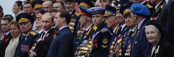 Russia's newly-inaugurated President Vladimir Putin (4th L) and new Prime Minister Dmitry Medvedev (5th L) speak as they watch Victory Day parade at the Red Square in Moscow, on May 9, 2012. Thousands of Russian soldiers marched today across Red Square to mark the 67 years since the victory over Nazi Germany in World War II. AFP PHOTO / NATALIA KOLESNIKOVA (Photo credit should read NATALIA KOLESNIKOVA/AFP/GettyImages)