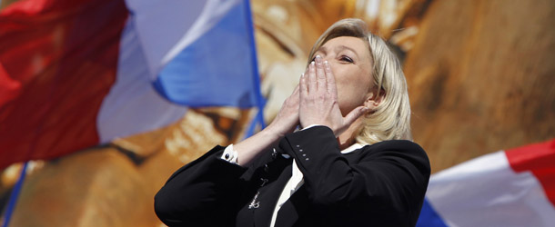 French far right party Front National (FN) candidate Marine Le Pen thanks the audience after delivering a speech on May 1, 2012 at the Opera square in Paris, during the party's celebrations of Joan of Arc, marking this year her 600th birth anniversary. Anti-immigrant candidate Marine Le Pen, knocked out in the 2012 presidential election, on April 22 first round, after scoring a record 18 percent of votes, helds today her yearly own rally in Paris. Background, (R), Wallerand de Saint Just, member of the FN Executive committee. AFP PHOTO / KENZO TRIBOUILLARD (Photo credit should read KENZO TRIBOUILLARD/AFP/GettyImages)