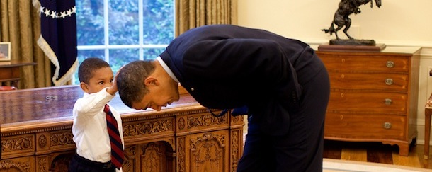 President Barack Obama bends over so the son of a White House staff member can pat his head during a visit to the Oval Office May 8, 2009. Official White House Photo by Pete Souza. This official White House photograph is being made available for publication by news organizations and/or for personal use printing by the subject(s) of the photograph. The photograph may not be manipulated in any way or used in materials, advertisements, products, or promotions that in any way suggest approval or endorsement of the President, the First Family, or the White House.