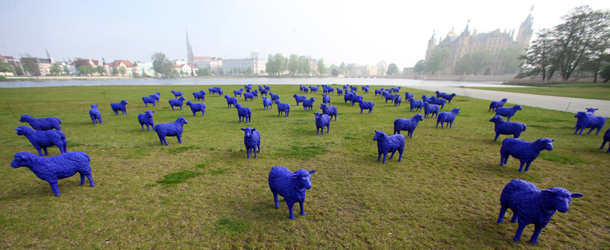 A flock of blue plastic sheep stand in front of the Schwerin Castle on May 4, 2012 in Schwerin, northeastern Germany. The sheep created by German artists Rainer Bonk and Bertamaria Reetz are part of an art project, that is touring Europe since three years already. According to the artists, they shall transport the peaceful message "all are equal - everyone is important". In every of the more than 50 European cities, where the flock was on display, one sheep was left as peace ambassador. AFP PHOTO / JENS BUTTNER GERMANY OUT (Photo credit should read JENS BUTTNER/AFP/GettyImages)