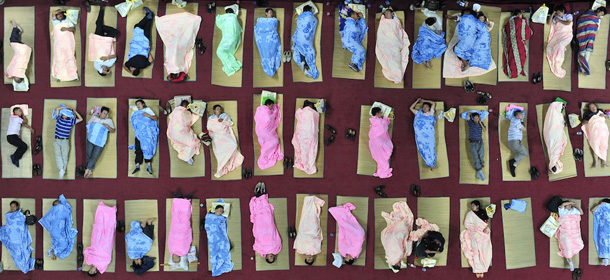 WUHAN, CHINA - SEPTEMBER 03: (CHINA OUT) Parents of newly arrived freshmen students sleep on the floor of the Youming Gymnasium at the Central China Normal University on September 3, 2011 in Wuhan, Hubei Province of China. The university opens its gymnasium for the parents who sent their newly enrolled students to the college in the new term. (Photo by ChinaFotoPress/Getty Images)