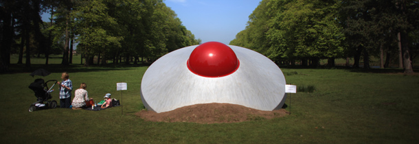 KNUTSFORD, ENGLAND - MAY 21: A family take a picnic next to a crashed flying saucer, an artwork entitled 'Vex' by artist Dinu Li, at Tatton Park as part of the 2012 Tatton Biennial on May 21, 2012 in Knutsford, England. This years exhibition explores 'Flights of Fancy' and displays the work of more than 20 artists at the National Trust property in Cheshire. The exhibition runs until September. (Photo by Christopher Furlong/Getty Images)