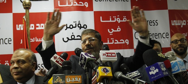 Egypt's Muslim Brotherhood candidate Mohammed Mursi (C) waves amongst his supporters after the announcement of presidential election results at the electoral headquarters in Cairo on June 18, 2012. The campaign of Egyptian presidential candidate Ahmed Shafiq said on June 18 it contested a claim by the Muslim Brotherhood that its candidate Mohammed Mursi had won a historic presidential election. AFP PHOTO / MOHAMMED ABED (Photo credit should read MOHAMMED ABED/AFP/GettyImages)