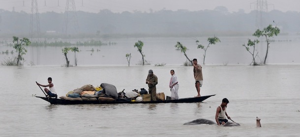 A mahout moves an elephant to higher ground as villagers padddle with their belongings through flood waters in the Pobitora Wildlife Sanctuary, some 55 kms from Guwahati, the capital city of the northeastern state of Assam on June 28, 2012. Floodwaters have submerged some 90 per cent of the sanctuary forcing rhinos and other wild animals to shelter in the woodland of the park which is located at a higher altitude. More than 850,000 people have been displaced and road communication disrupted in several parts of the state due to flooding caused by seasonal monsoon rains, a government official said. AFP PHOTO/Biju BORO (Photo credit should read STRDEL/AFP/GettyImages)