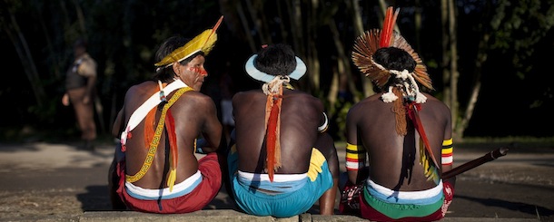 Caiapo tribe members sit on a curb at the Kari-Oca village, where indigenous from around the world are staying during the United Nations Conference on Sustainable Development, or Rio+20, in Rio de Janeiro, Brazil, Wednesday, June 13, 2012. The Rio+20 conference is expected to draw some 50,000 participants including delegates, environmental activists, business leaders and indigenous groups. The event runs through June 22, with three final days of high-profile talks among some 130 top leaders from nations around the globe. (AP Photo/Felipe Dana)