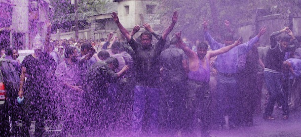 Police use colored water from a water cannon to disperse Kashmiri government employees protesting against the government in Srinagar, India, Wednesday, June 13, 2012. The employees demanded payment of arrears in salaries and raising of retirement age among other demands. (AP Photo/Mukhtar Khan)