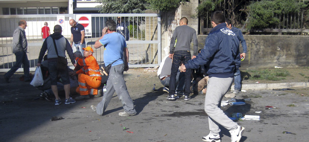 EDS NOTE: GRAPHIC CONTENT - In this photo taken Saturday, May 19, and made available Monday, May 21, 2012, victims of the bomb blast at the "Francesca Morvillo Falcone" high school in Brindisi, Italy, receive first aid immediately after the explosion. Investigators had no firm clue Sunday of who was behind the attack and there was still no claim of responsibility a day after the crude device made up of gas cylinders exploded outside a mainly all-girls vocational school in the Adriatic port town of Brindisi, killing a 16-year-old student and wounding several others. (AP Photo/Massimo Guastella)