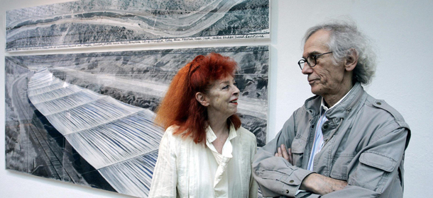 Rostock, GERMANY: Artists Christo (R) and Jean-Claude stand 15 July 2005 beside a drawing of their work in progress "Over the river, a project for the Arkansas River, State of Colorado" documented in their show at Rostock's Kunsthalle. Togheter with the Paris project "The Pont Neuf, wrapped", 1975-1985, the artist's works will be presented to the public from 16 July to 08 October 2006. AFP PHOTO DDP/JENS KOEHLER GERMANY OUT (Photo credit should read JENS KOEHLER/AFP/Getty Images)