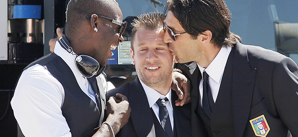 Italy' s national football team players Mario Balotelli (L), Antonio Cassano (C) and Gianluigi Buffon pose for a photograph prior to boarding an Alitalia flight to Cracovia, Poland, for the upcoming Euro 2012 football championship held in Poland and Ukraine, at Pisa' s airport on June 5, 2012. AFP PHOTO / STRINGER (Photo credit should read STR/AFP/GettyImages)