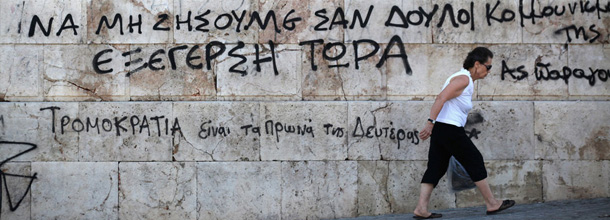 ATHENS, GREECE - JUNE 13: A woman walks past a wall of a university building covered in graffiti on June 13, 2012 in Athens, Greece. The Greek electorate are due to go to the polls in a re-run of the general election on June 17, 2012 after no combination of political parties were able to form a coalition government. Recent opinion polls have placed the anti-bailout party 'Syriza' equal in popularity with the pro-bailout 'New Democracy' ahead of Sunday's general election which could determine whether Greece retains the Euro as its currency. (Photo by Oli Scarff/Getty Images)