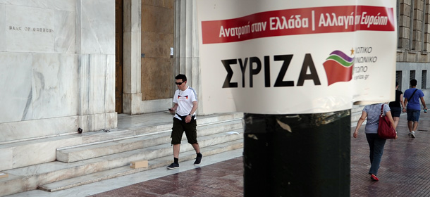 People walk by the bank of Greece headquarters and an election poster of the left coalition party Syriza in Athens on June 7, 2012. Greece's election campaign warmed up Thursday as the conservatives released a new alarmist campaign ad and police sought a neo-Nazi MP over an assault of two female lawmakers live on TV. Many of the parties that won such huge support last month, most notably the second-placed Syriza leftists, want to renegotiate or even tear up the terms of the bailouts. . AFP PHOTO/ LOUISA GOULIAMAKI (Photo credit should read LOUISA GOULIAMAKI/AFP/GettyImages)