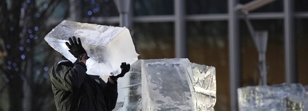 An ice sculpture carries a block of ice during the London Ice Sculpting Festival in Canary Wharf, east London, on January 13, 2012. Competitors battled it out with chainsaws and ice picks in the London Ice Sculpting contest. AFP PHOTO / CARL COURT (Photo credit should read CARL COURT/AFP/Getty Images)