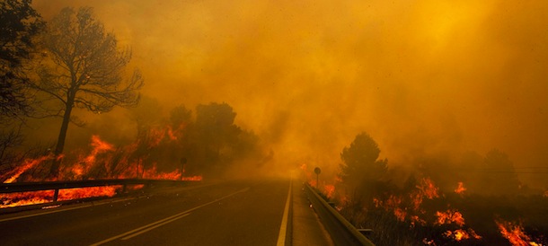 A wildfire spreads around a road in Yatova, near Valencia on June 30, 2012. A forest fire in eastern Spain forced 700 people to evacuate their homes and indirectly caused a brief power cut at a nuclear plant, authorities said. The fire had burned 10 square kilometres (3.8 square miles) of land in the Valencia region, its government said in a statement. AFP PHOTO / German Garcia (Photo credit should read German Garcia/AFP/GettyImages)