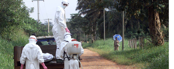 A woman, right, waits until a pickup truck bearing the corpse of an Ebola victim and workers wearing protective clothing has passed on their way to the cemetary, Friday Dec. 28, 2001 in Mekambo, Gabon. Twenty-three people have died so far in the region -- 17 in Gabon and six in neighboring Republic of Congo. (AP Photo/Christine Nesbitt)
