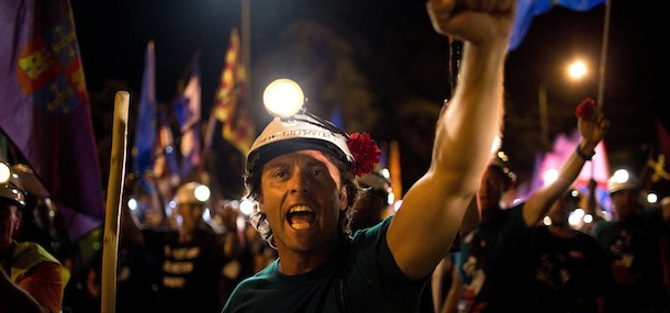 Miners sing as they march along the street after walking for more than 20 days from the northern Asturias and Leon regions, as many as 400 kilometers (250 miles), on their way to Puerta del Sol, the Spanish capital's most emblematic square in Madrid, Spain, July 10, 2012. Coal miners angered by huge cuts in subsidies converged on Madrid Tuesday for protest rallies after walking nearly three weeks under a blazing sun from the pits where they eke out a living. (AP Photo/Emilio Morenatti)