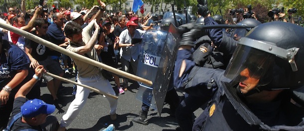 Demonstrators and the riot police clash during the coal miners's march to the Minister of Industry's building in Madrid, Wednesday, July 11, 2012. Coal miners angered by huge cuts in subsidies converged on Madrid Tuesday for protest rallies after walking nearly three weeks under a blazing sun from the pits where they eke out a living. (AP Photo/Andres Kudacki)