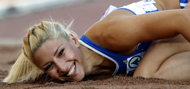 FILE- Greece's Voula Papachristou lands in the sand after her jump at the Women's Triple Jump final at the European Athletics Championships in Helsinki, Finland, in this file photo dated Friday, June 29, 2012. The Hellenic Olympic Committee has removed triple jumper Voula Papachristou from the team taking part in the upcoming London Olympic Games over comments she made on twitter making fun of African immigrants and expressing support for a far-right party. Ã¬The track and field athlete Paraskevi (Voula) Papachristou is placed outside the Olympic Team for statements contrary to the values and ideas of the Olympic movement,Ã® a statement by the Hellenic Olympic Committee says. Papachristou is in Athens, and was to travel to London Ã¬shortly before the track events start,Ã® the announcement says.(AP Photo/Matt Dunham, file)