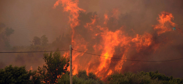 Flames burn trees and bushes during an wildfire near Patras, Greece, Wednesday, July 18, 2012. Regional authorities declared an emergency in southwestern Greece as wildfires threatened village homes outside the city of Patras. Nine planes and one helicopter were involved in the firefighting effort Wednesday at Argyra, some 15 kilometers (9.3 miles) east of Patras, amid high winds and temperatures above 40 degrees Celsius (104 Fahrenheit). (AP Photo/Giannis Androutsopoulos)