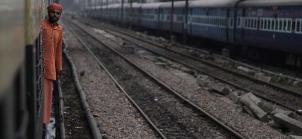 An Indian passenger looks out from the compartment of a stationary train following the power outage that struck in the early hours of Monday, July 30, 2012 at a train station in New Delhi, India. Northern India was plunged into darkness Monday after a supply grid tripped because of overloading, officials said. (AP Photo/Altaf Qadri)