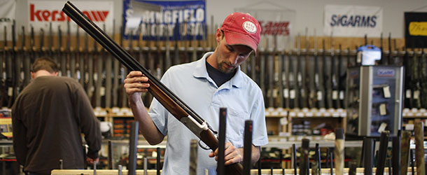 ** RETRANSMISSION TO CORRECT RIFLE TO SHOTGUN ** Adam Henderson shops for a shotgun at Guns and Leather, a firearms store and shooting range, in Greenbrier, Tenn. on Friday Dec. 11, 2009. A nationwide review by The Associated Press found that over the last two years, 24 states, mostly in the South and West, have passed 47 new laws loosening gun restrictions. (AP Photo/Josh Anderson)