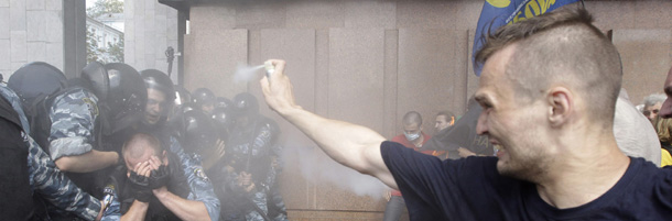 Opposition protesters spray tear gas against riot police in front of the Ukrainian House in central Kiev, Ukraine, Wednesday, July 4, 2012. Opposition activists have clashed with riot police during a protest against a controversial bill that would allow the use of Russian in official settings in Russian-speaking regions. (AP Photo/Efrem Lukatsky)