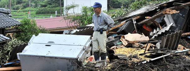 A worker stands among the debris of a landslide trace after torrential rainfall in Aso City, Kumamoto prefecture on July 17, 2012. Flood victims in Japan began a full-scale clean-up operation after record rainfall forced hundreds of thousands to flee and left at least 32 dead or missing. AFP PHOTO / KAZUHIRO NOGI (Photo credit should read KAZUHIRO NOGI/AFP/GettyImages)