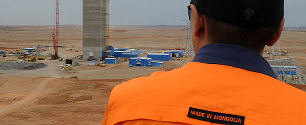 This photo taken on June 23, 2012 shows a worker looking at the construction of the second mining shaft of the Oyu Tolgoi gold and copper mine which is operated by Rio Tinto and Ivanhoe Mines and is due to begin large scale production due next year in south east Mongolia. Mongolia, a former Soviet satellite state, has struggled to develop a sustainable economy since turning to capitalism two decades ago but its rich deposits of copper, gold, uranium, silver and even oil have caught the eye of foreign investors. Mining now accounts for close to 30 percent of its GDP and 70 percent of its exports. AFP PHOTO/Mark RALSTON (Photo credit should read MARK RALSTON/AFP/GettyImages)