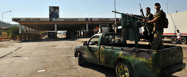 Syrian rebels stand on a vehicle after seizing control of the Bab el Hawa border post with Turkey on July 20, 2012 in Bab al-Hawa. Syrian rebels seized control of the Bab Al-Hawa border post with Turkey today after a fierce battle with Syrian troops, an AFP photographer at the scene reported. Some 150 armed rebel fighters were in control of the post, which lies opposite Turkey's Cilvegozu border crossing in the southern province of Hatay. AFP PHOTO / BULENT KILIC (Photo credit should read BULENT KILIC/AFP/GettyImages)