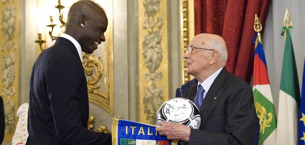 In this photo released by the Italian Presidency Press Office, Italian President Giorgio Napolitano receives from forward Mario Balotelli a soccer ball signed by the players of the Italian soccer team that placed second at the Euro 2012 European Championship, as he received the Italian team at the Quirinale presidential palace in Rome upon their return from Krakow, Poland, Monday, July 2, 2012. (AP Photo/Paolo Giandotti, Italian Presidency)